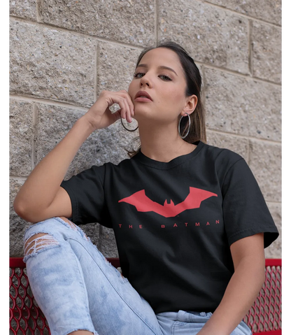 Woman wearing Unisex short sleeve black t-shirt featuring official DC Comics The BATMAN text in red and red Bat logo design / Retro Tees