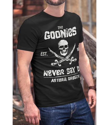 Man wearing Unisex short sleeve black t-shirt featuring official Warner Bros The Goonies movie poster skull and cross swords design with the iconic text The Goonies, Never Say Die / Retro Tees